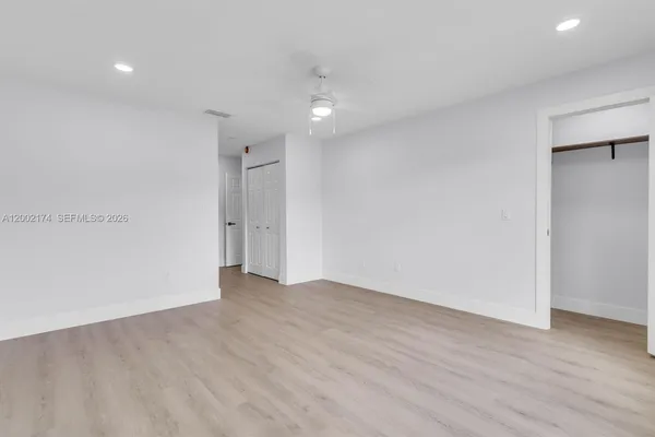 a view of an empty room with wooden floor