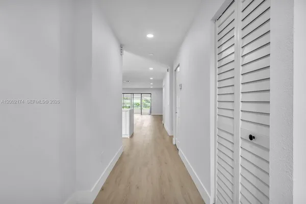 a view of a hallway with wooden floor and staircase