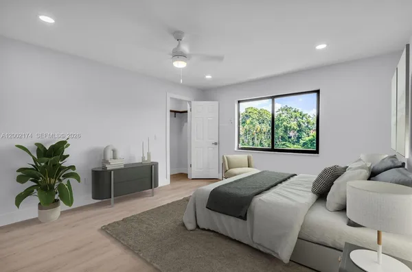 a bedroom with a large bed and a potted plant