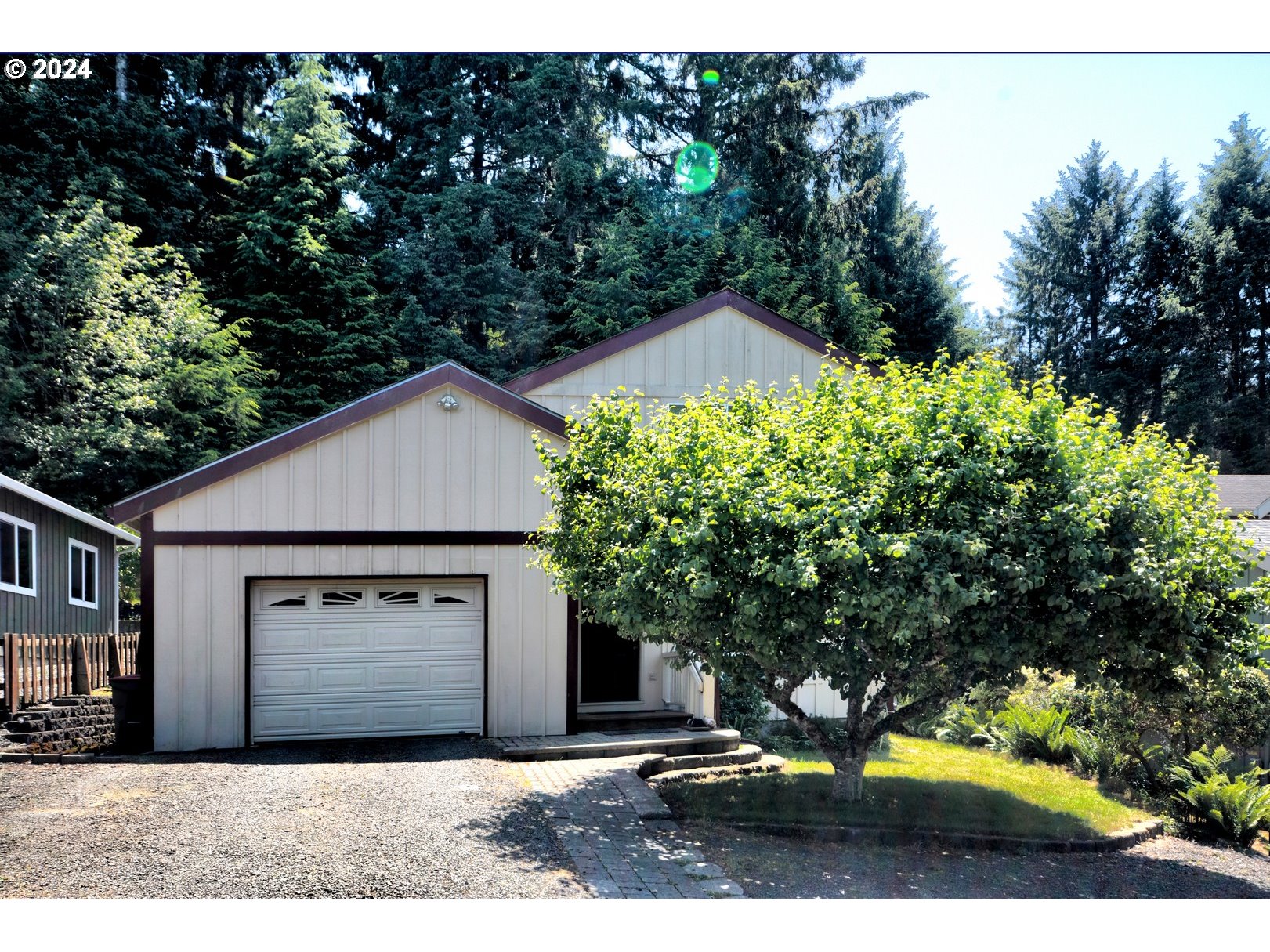 421 Elk Creek Road Cannon Beach, OR 97110 - Photo 2 of 16 a front view of a house with a yard and garage