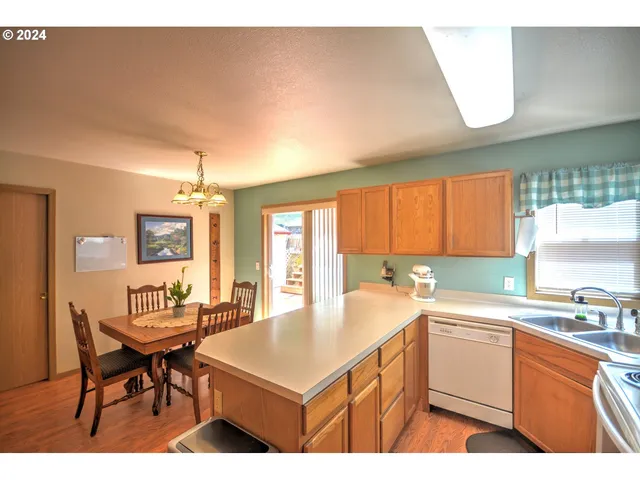 a kitchen with a sink a counter top space and living room view