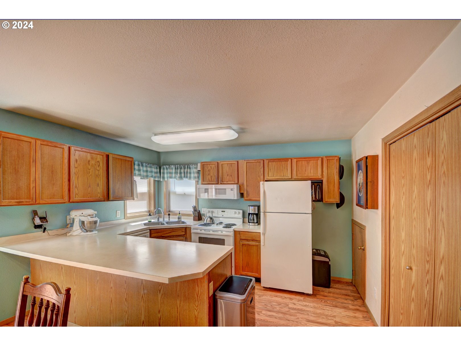 421 Elk Creek Road Cannon Beach, OR 97110 - Photo 8 of 16 a kitchen with a sink a refrigerator and a stove
