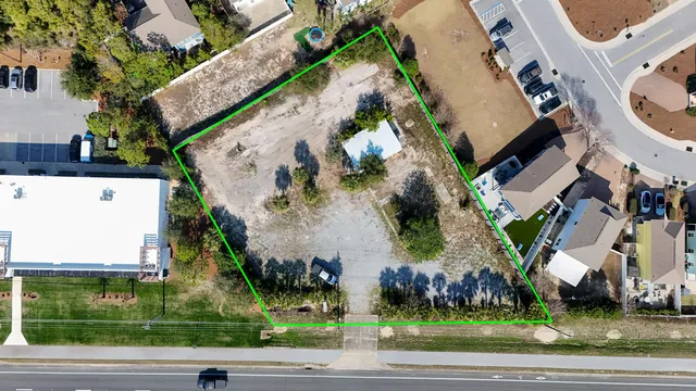 an aerial view of a residential apartment building with a yard and parking space