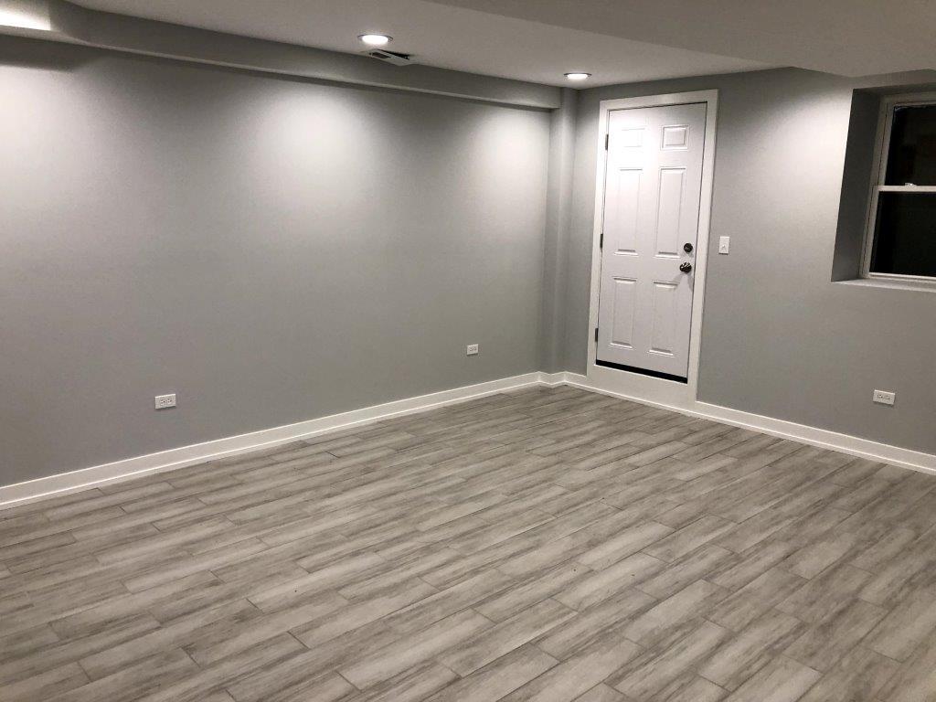 3210 South May Street, Unit B Chicago, IL 60608 - Photo 3 of 12 an empty room with wooden floor and windows