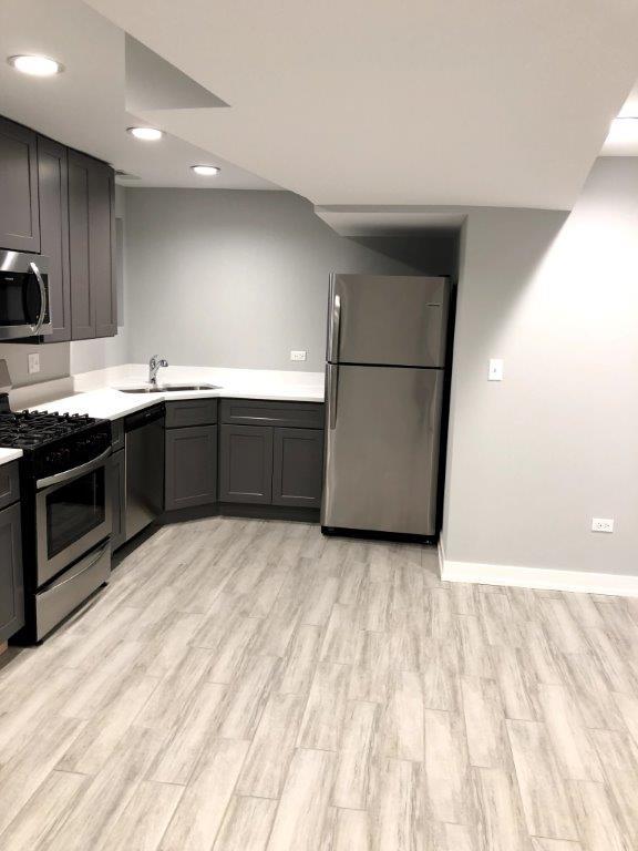 3210 South May Street, Unit B Chicago, IL 60608 - Photo 5 of 12 a kitchen with stainless steel appliances a sink and a refrigerator