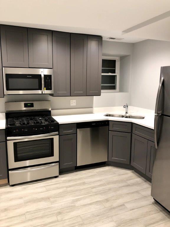 3210 South May Street, Unit B Chicago, IL 60608 - Photo 6 of 12 a kitchen with stainless steel appliances kitchen island granite countertop a stove a sink and a microwave