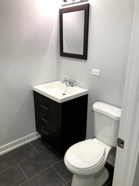 3210 South May Street, Unit B Chicago, IL 60608 - Photo 9 of 12 a bathroom with a toilet sink and mirror