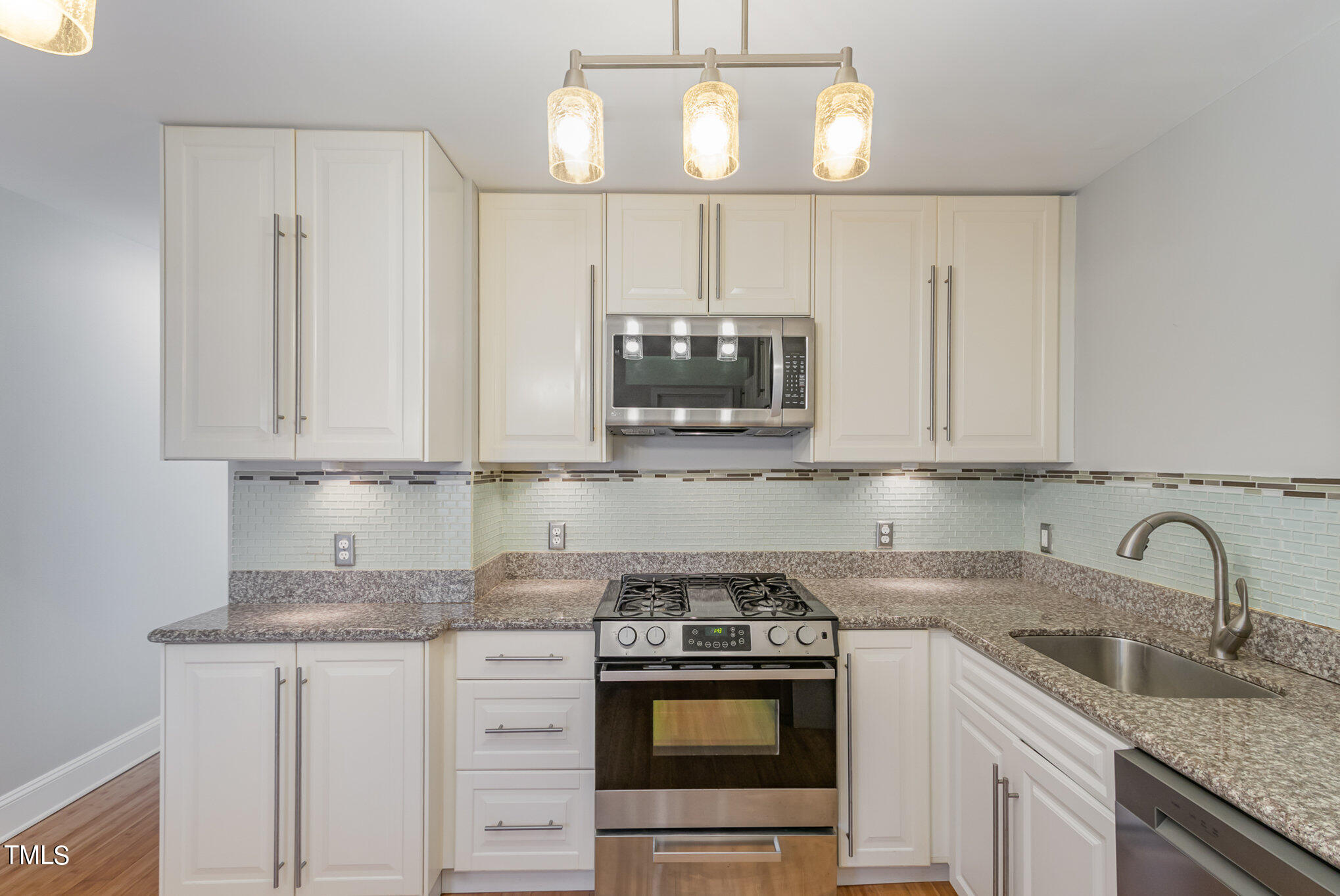2548 Noble Road Raleigh, NC 27608 - Photo 13 of 27 a kitchen with stainless steel appliances granite countertop a sink stove and microwave
