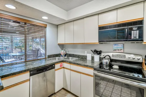 a kitchen with stainless steel appliances a sink a stove and cabinets