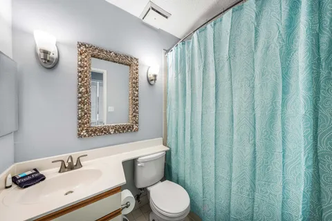 a bathroom with a sink a toilet and shower curtain