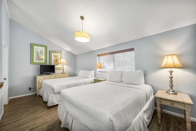 a bedroom with two beds and a lamp