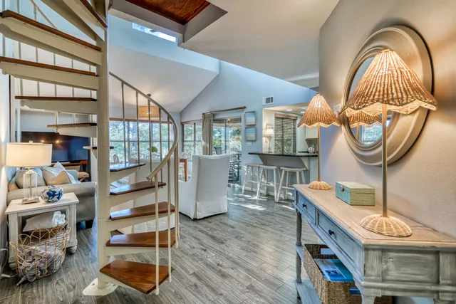 a living room with furniture a fireplace and a dining table with wooden floor