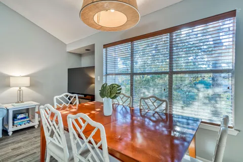 a view of a dining room with furniture a chandelier and wooden floor