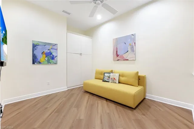 a living room with couch and a painting on the wall