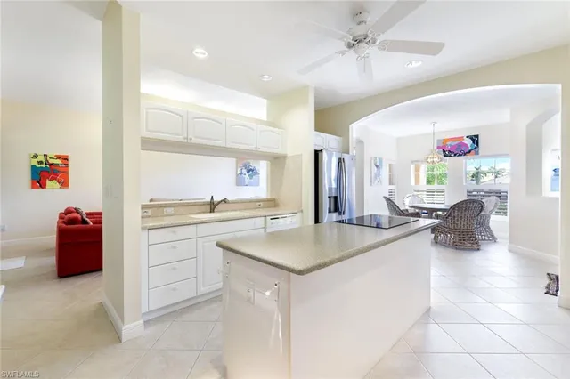 a kitchen with a sink dishwasher and white cabinets with wooden floor