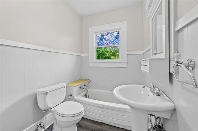a bathroom with a toilet sink and mirror