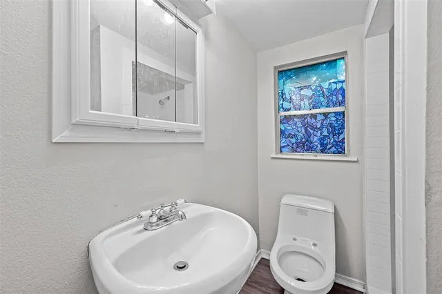 a bathroom with a toilet a sink and mirror