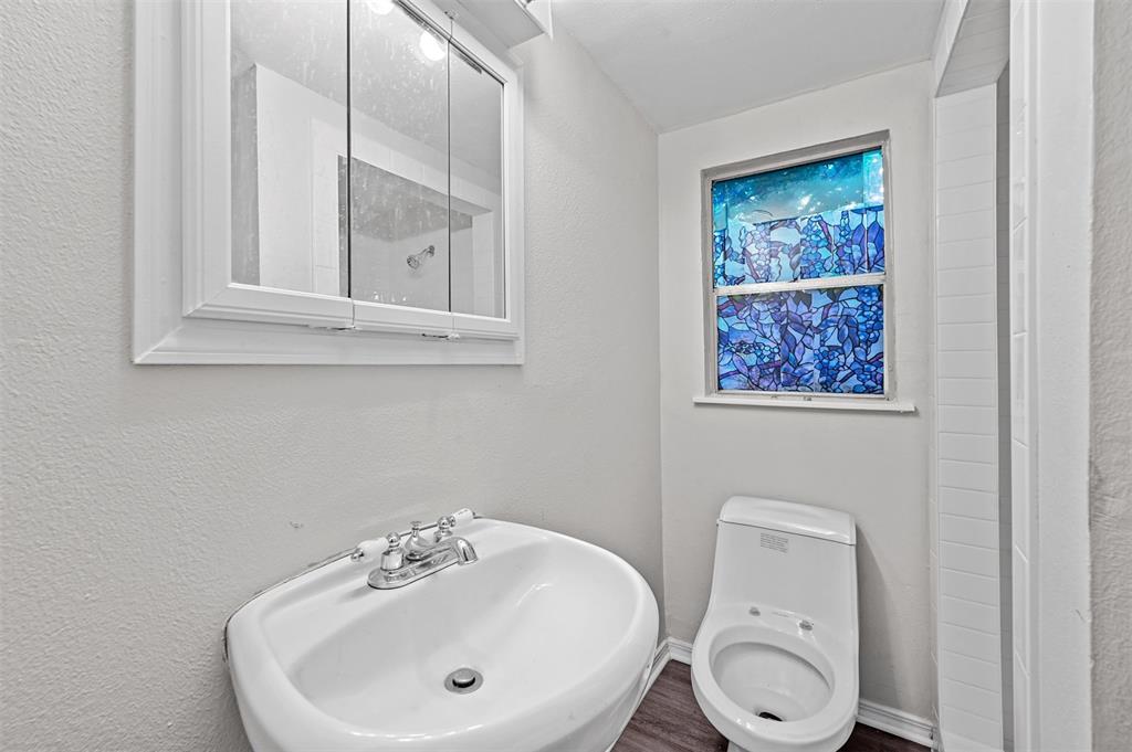520 Brooks Avenue Dallas, TX 75208 - Photo 16 of 22 a bathroom with a toilet a sink and mirror