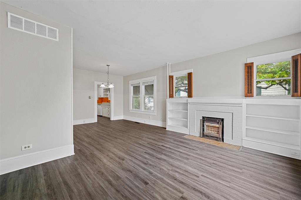 520 Brooks Avenue Dallas, TX 75208 - Photo 3 of 22 an empty room with wooden floor fireplace and windows