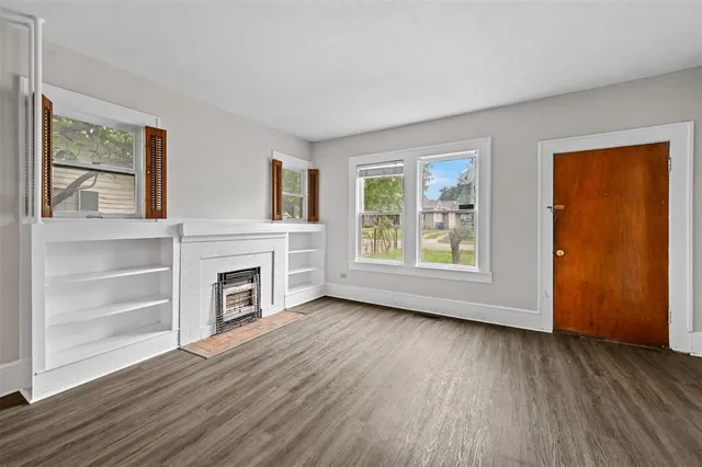 a view of an empty room with a window and fireplace