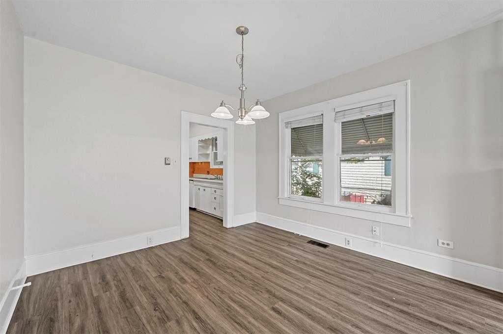 520 Brooks Avenue Dallas, TX 75208 - Photo 6 of 22 a view of an empty room with window and wooden floor