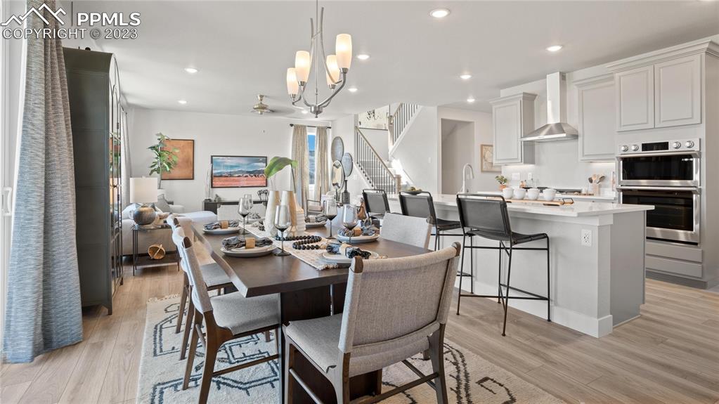 2174 Coyote Mint Drive Monument, CO 80132 - Photo 24 of 50 a dining area with stainless steel appliances kitchen island granite countertop a sink a stove a dining table and chairs
