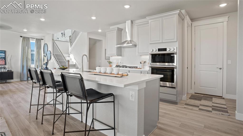 2174 Coyote Mint Drive Monument, CO 80132 - Photo 25 of 50 a kitchen with stainless steel appliances kitchen island granite countertop a table chairs sink and cabinets