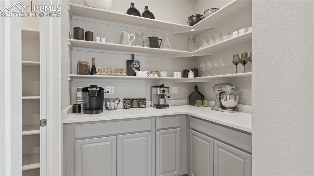 2174 Coyote Mint Drive Monument, CO 80132 - Photo 30 of 50 a kitchen with white cabinets and a wooden floor