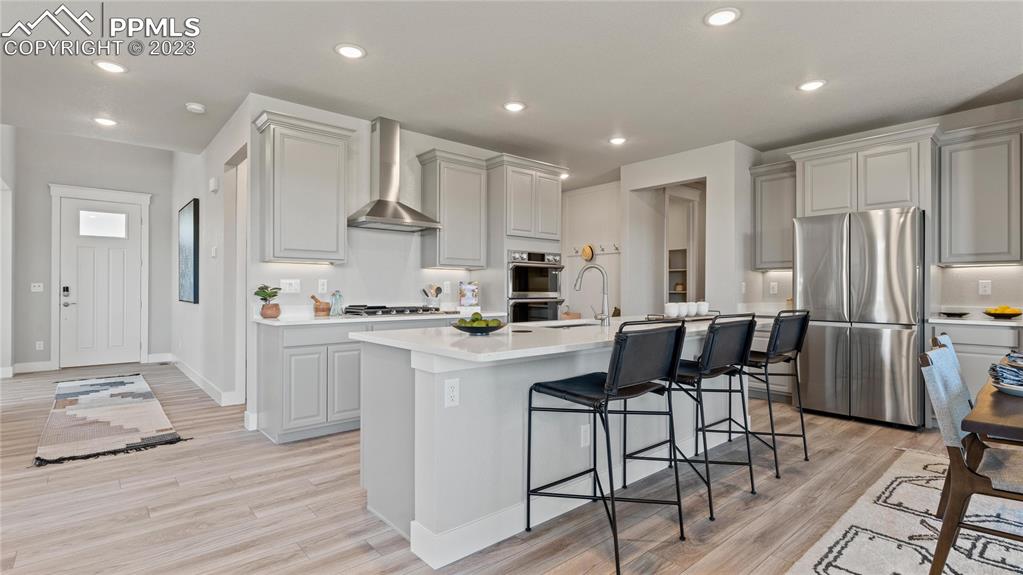 2174 Coyote Mint Drive Monument, CO 80132 - Photo 32 of 50 a kitchen with stainless steel appliances kitchen island granite countertop a refrigerator and a stove top oven