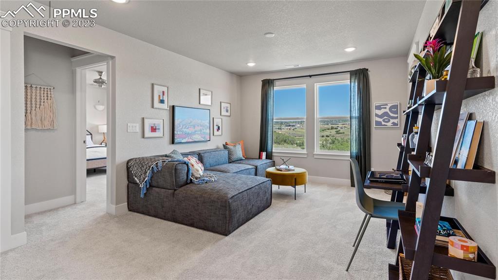 2174 Coyote Mint Drive Monument, CO 80132 - Photo 35 of 50 a living room with furniture and a floor to ceiling window