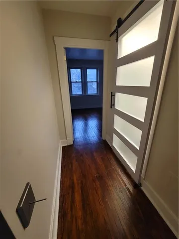 a view of a hallway with wooden floor and stairs