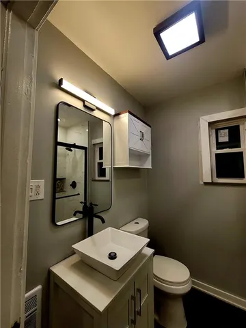 a bathroom with a toilet a sink and mirror