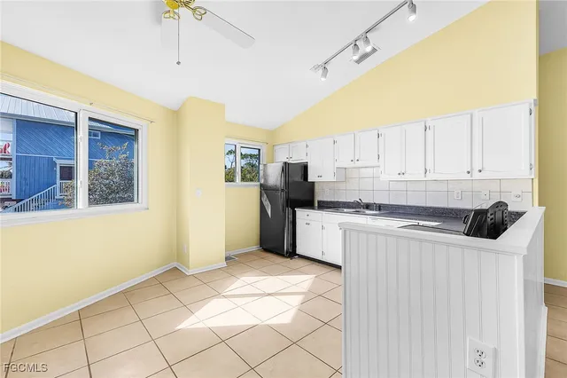 a kitchen with stainless steel appliances granite countertop a refrigerator a sink a stove and white cabinets