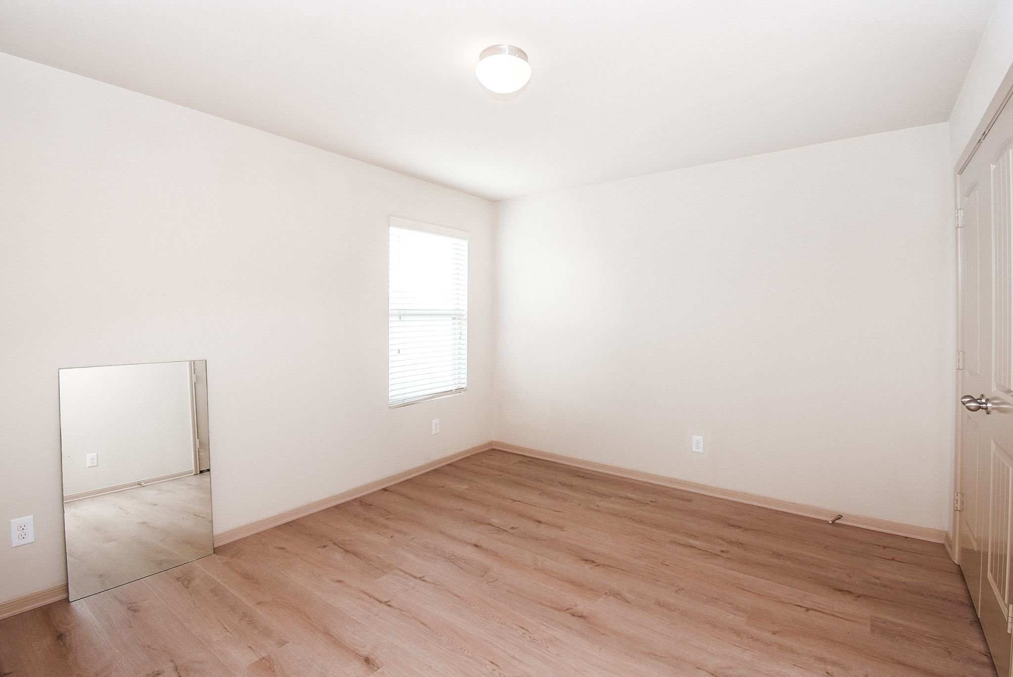 2106 Harmon Crest Court Spring, TX 77373 - Photo 32 of 37 an empty room with wooden floor and windows