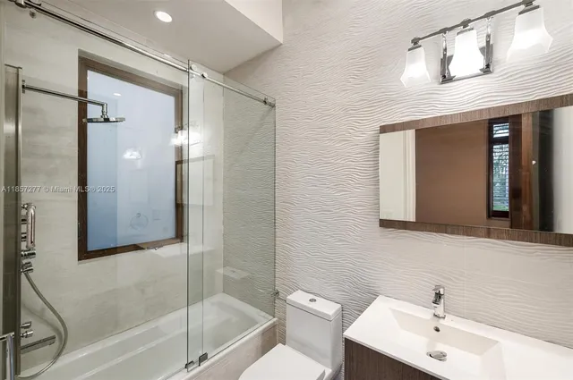 a view of an empty room with wooden floor and windows