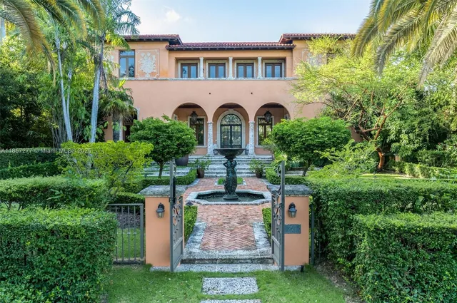 a front view of a house with a yard and fountain