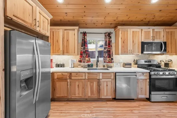 a kitchen with stainless steel appliances granite countertop a refrigerator a stove and a sink