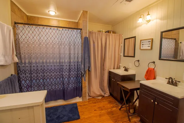 a bathroom with a sink a toilet a mirror and shower curtain