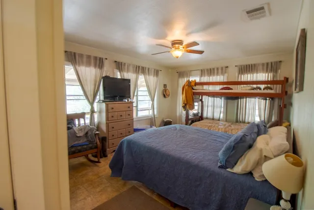 a bedroom with a bed window and a flat screen tv
