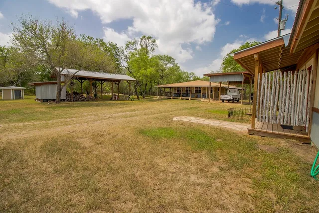 a view of a house with a yard and sitting area