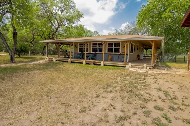 front view of house with a yard balcony and swimming pool