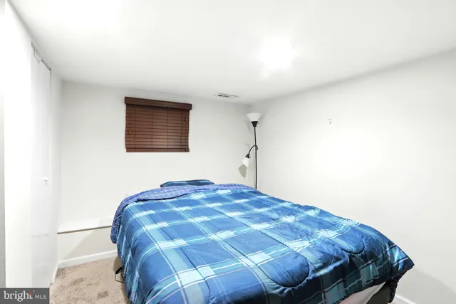 a bed sitting in a bedroom next to a window