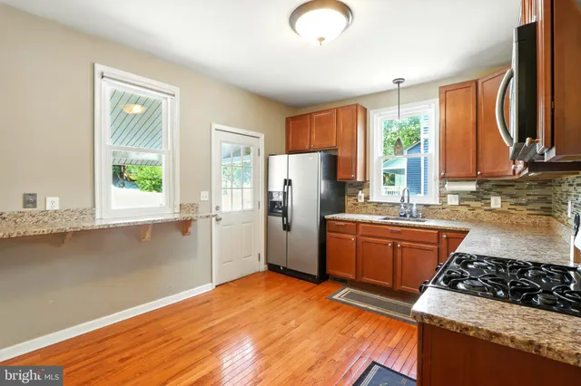 a kitchen with stainless steel appliances granite countertop a stove a refrigerator and a sink