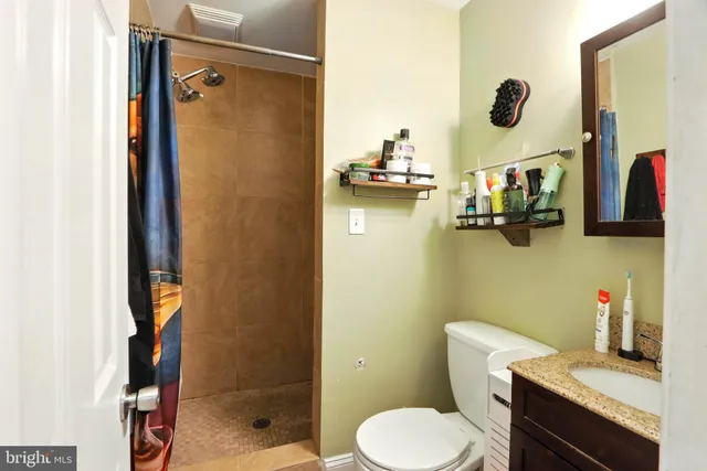 a bathroom with a sink mirror vanity and toilet