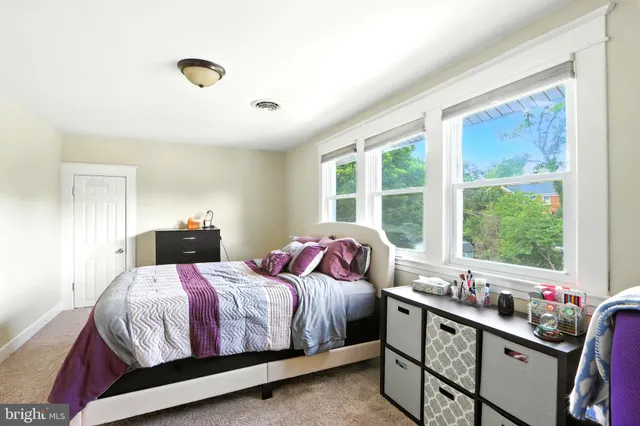 a bedroom with a bed and a large window