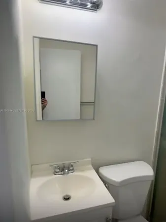 a bathroom with a sink a toilet and mirror