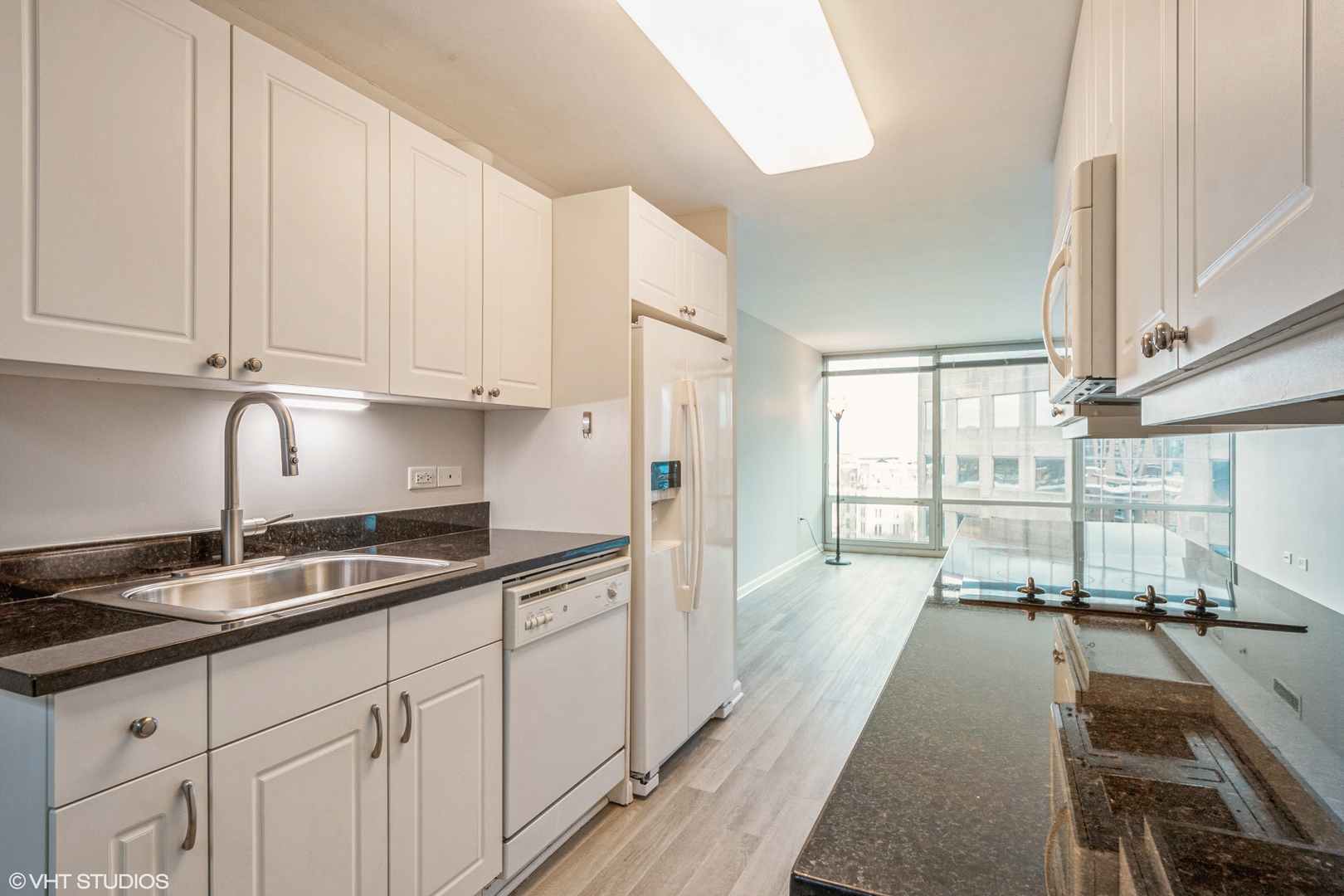 800 Elgin Road, Unit 1013 Evanston, IL 60201 - Photo 2 of 12 a kitchen with granite countertop a sink and white cabinets