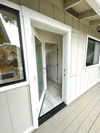 a view of a hallway with wooden floor and a large window