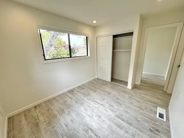 an empty room with wooden floor and a window
