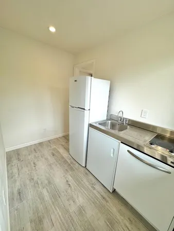a view of kitchen with granite countertop cabinets and sink